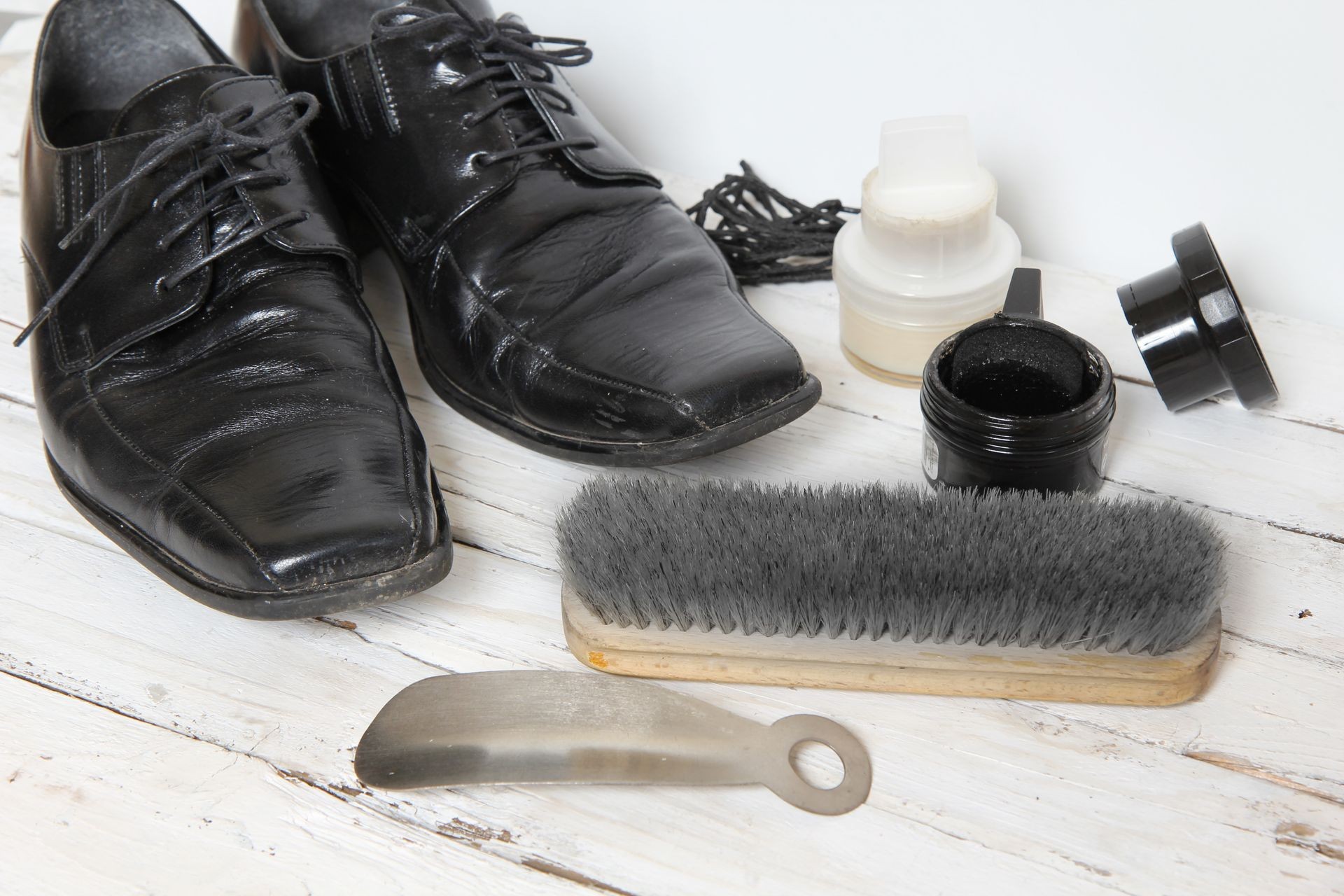 shoe care equipment and formal black shoe on white background